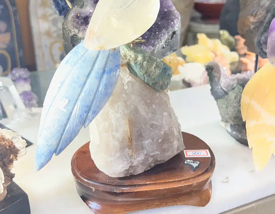 Pássaros coloridos esculpidos em pedra e cristal